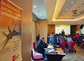 Afuzion : A business seminar in progress with attendees seated facing a presenter at the front, next to a banner about aviation systems.